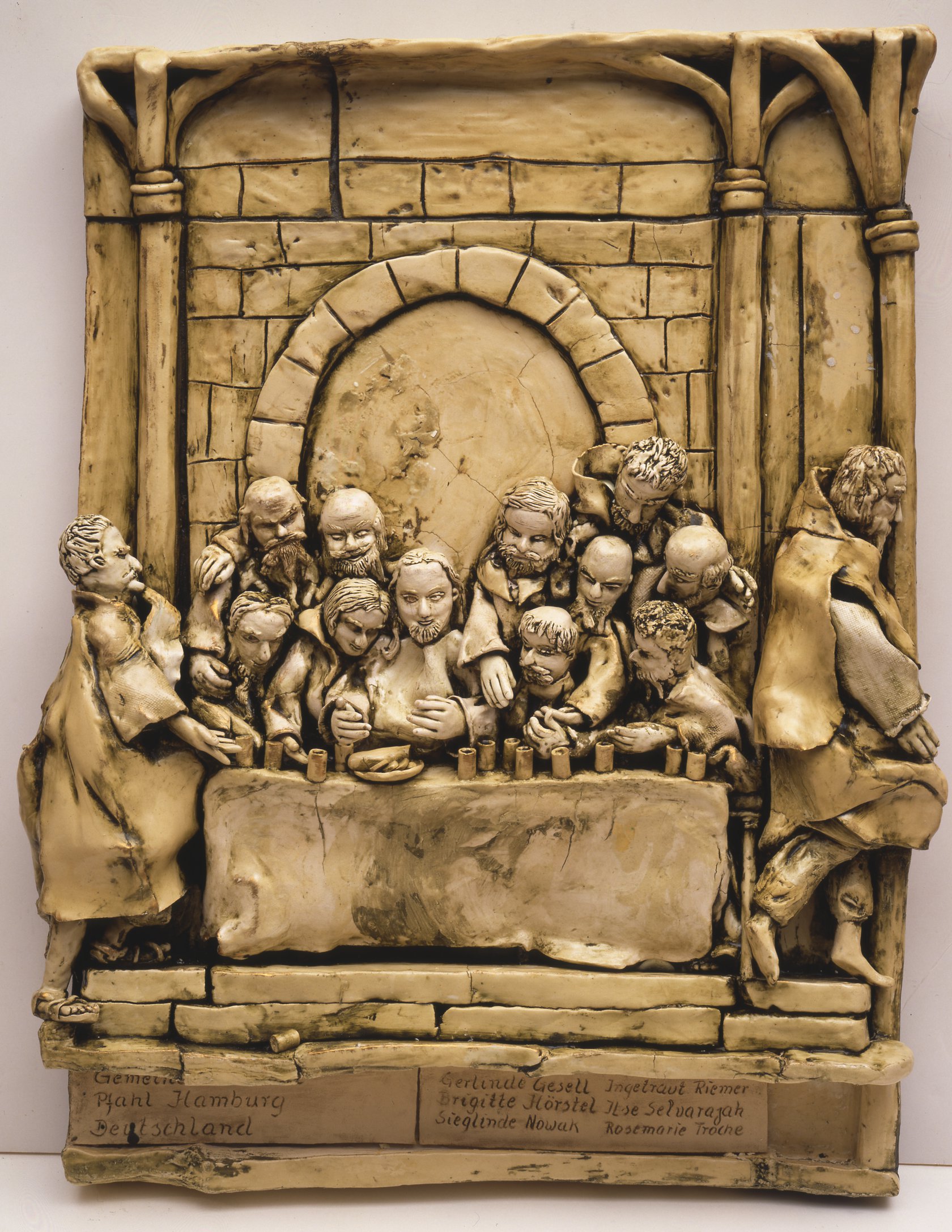 A ceramic representation of The Last Supper with Jesus surrounded by his disciples.