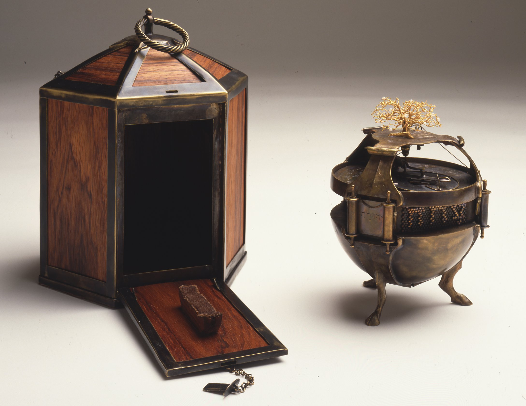 A round, metal object with feet and an open multi-sided wooden box.