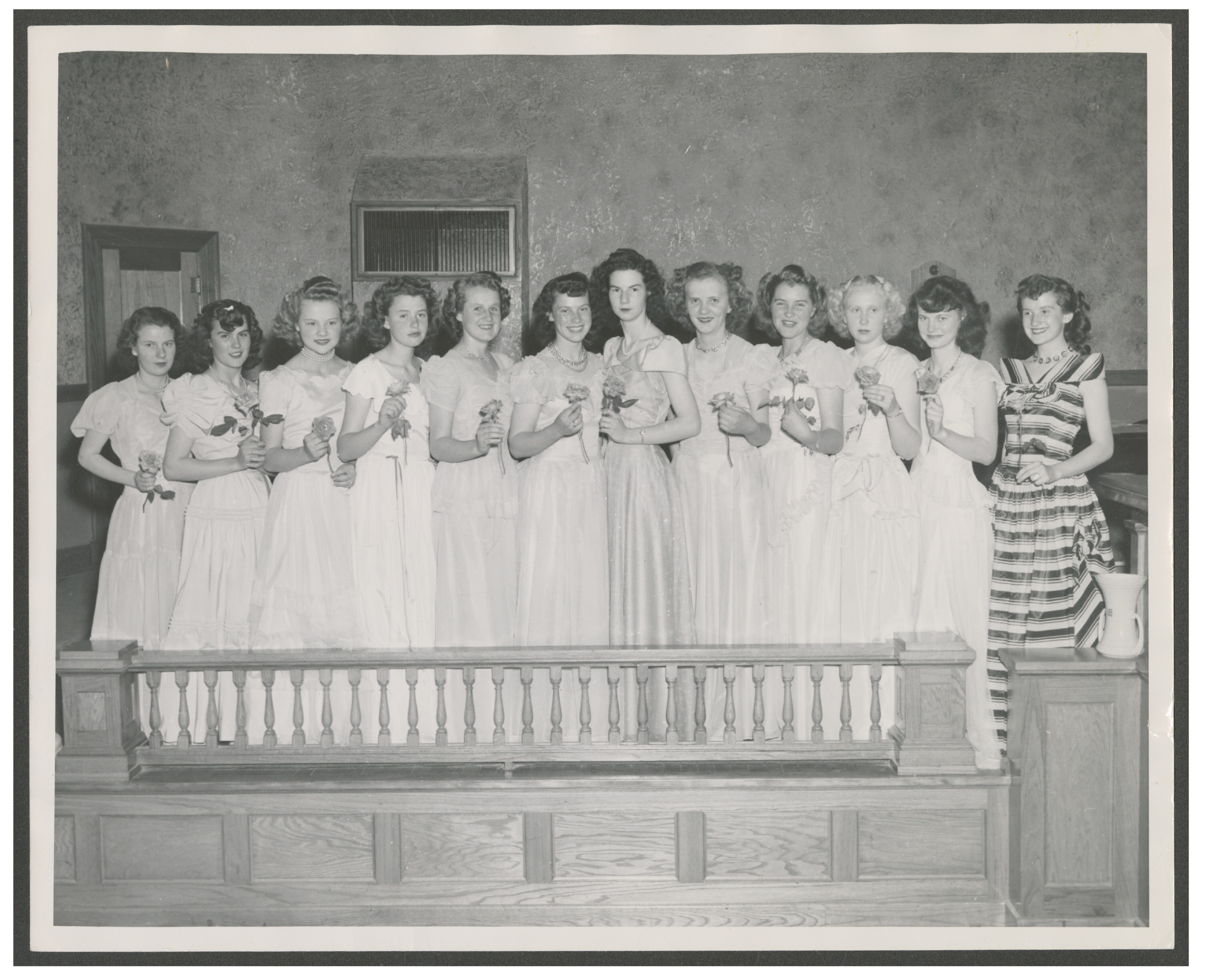 <strong>Rose Tying Ceremony, Aurora, Utah.</strong> 1948. This Junior Girls class from rural central Utah participated in the annual Rose Tying Ceremony, a formal celebratory evening where young women presented a rose—preferably one they had personally cultivated—whose color or type symbolized their personal ideals. The roses were then tied together and presented to the president of the ward YWMIA. This tradition was similar to the Gleaners’ sheaf-binding ceremonies, and both were major events on the YWMIA calendar. (Church History Library, Salt Lake City.) (Image courtesy Church History Library, Salt Lake City.)