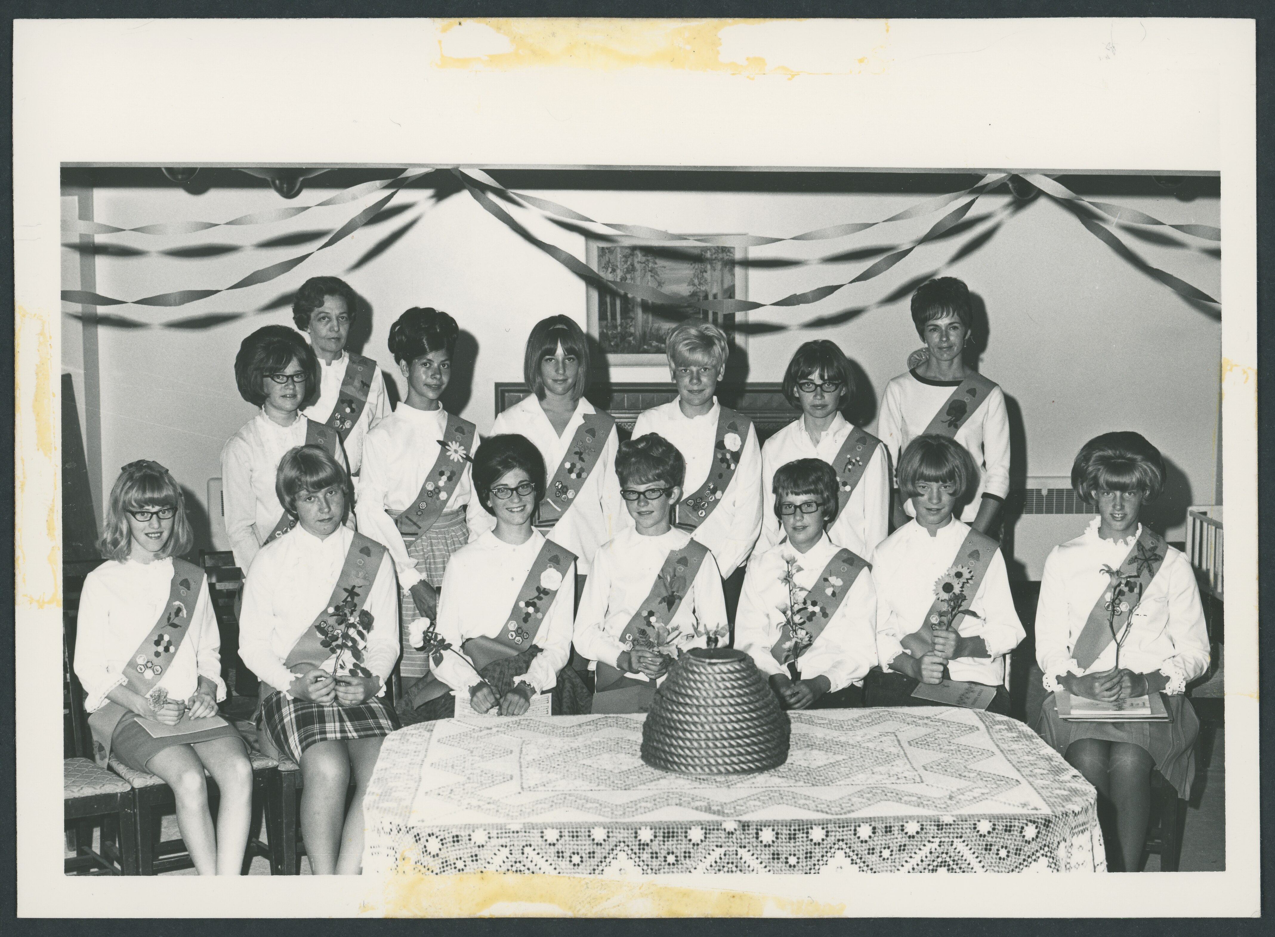 <strong>Rexburg Fifth Ward Honor Night.</strong> 1968. Even as the correlation movement initiated significant changes in the YWMIA, young women maintained time-honored traditions, such as this Beehive Honor Night in Rexburg, Idaho. The young women wore bandoliers—colloquially known as bandlos—personalized with their signature flower and achievement badges. Honor Nights began in the 1930s to celebrate individual achievement. (Image courtesy Church History Library, Salt Lake City.)