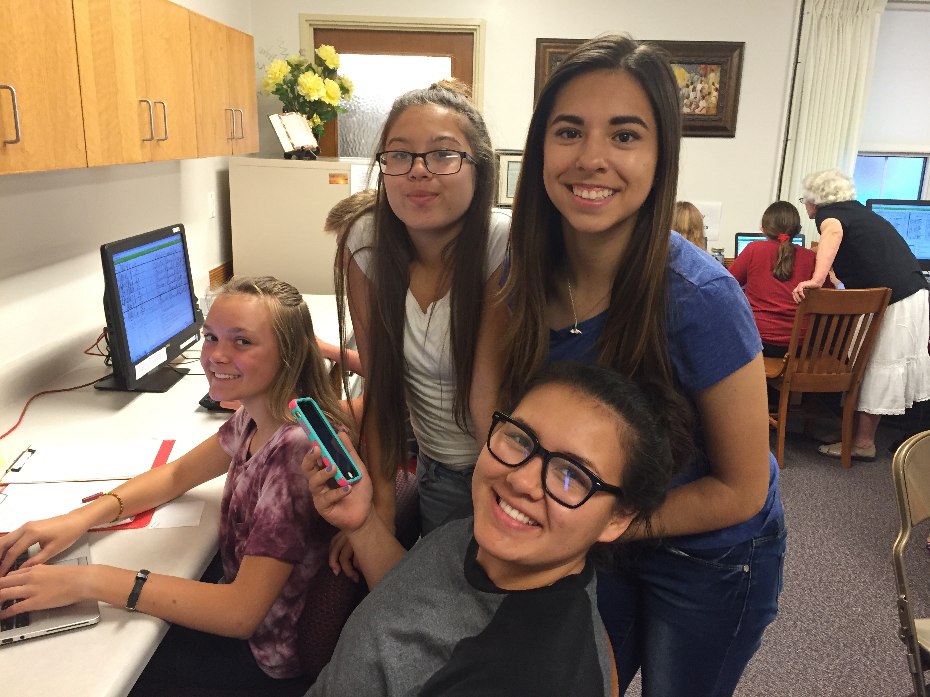 <strong>Young women participating in worldwide indexing event, Salt Lake City.</strong> 2016. Youth from the Northpoint Second Ward indexed names on FamilySearch at their local stake family history center as part of a global push for youth participation in family history work. Youth in the 2010s engaged in temple and family history work on FamilySearch.org via computer or on FamilySearch mobile apps developed for smartphones in 2014. (Photograph by Brittany Chapman Nash.)