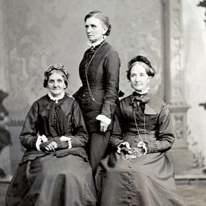 Eliza R. Snow (right), second Relief Society general president, chose Elizabeth Ann Whitney (left) as her first counselor in 1880 and called Emmeline B. Wells (standing, rear) to help train Relief Society leaders and organize Primary Associations. Photograph by Charles R. Savage. (PH 892, Church History Library, Salt Lake City.)
