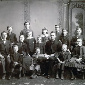 23 June 1884. Seated, left to right: Amelia Cannon, William T. Cannon, Read T. Cannon, Mary Alice Cannon, Joseph J. Cannon, Sander Saunders (teacher), Brigham T. Cannon, Hester Cannon. Standing: Charlie Davey Cannon, David H. Cannon, Hugh J. Cannon, Sylvester Q. Cannon, Willard T. Cannon, Emily Cannon, Angus J. Cannon, Rosannah Cannon, Lewis T. Cannon. (Church History Library, Salt Lake City. Photograph by Charles R. Savage.)